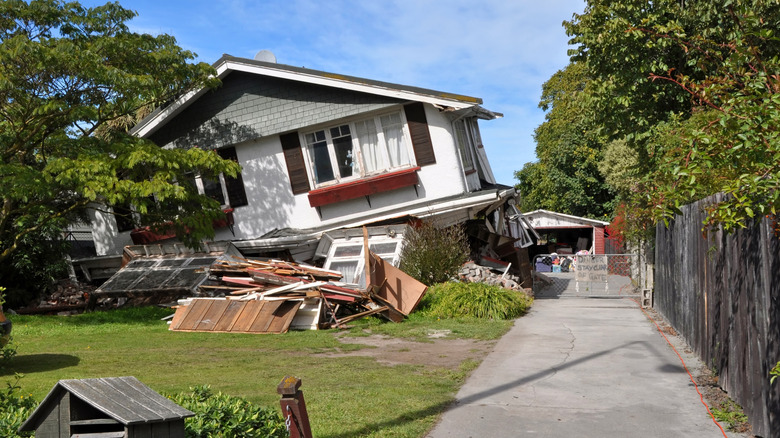 A house slipped off its foundation and collapsed in the aftermath of an earthquake.