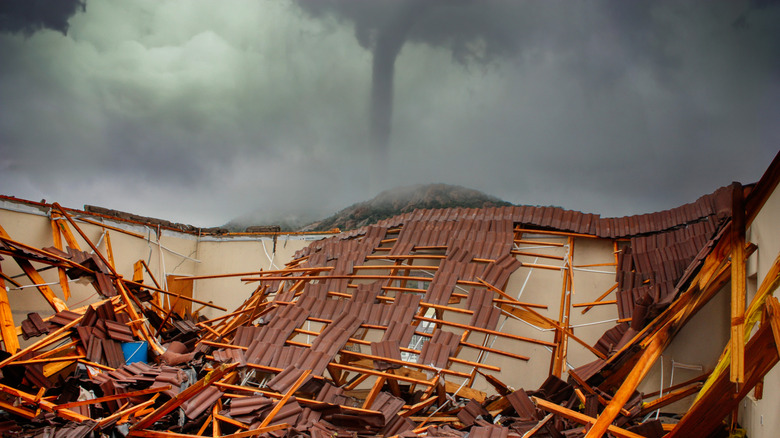 A demolished house with a twister behind it.