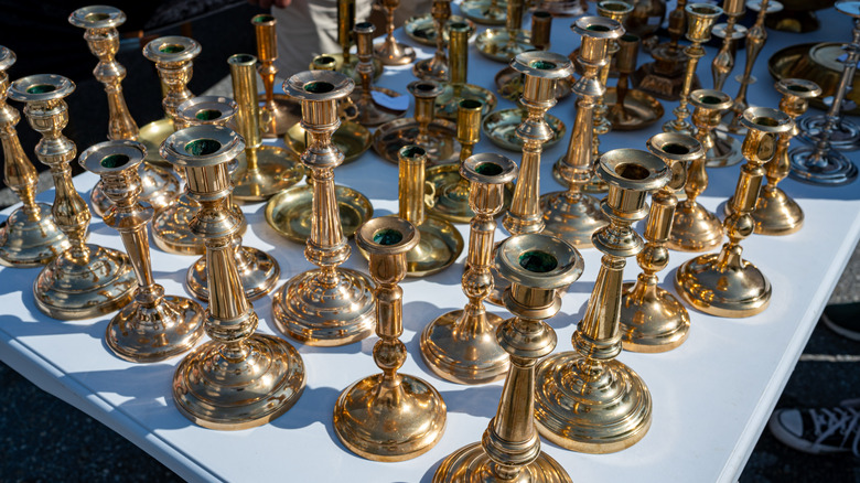 Table full of brass candlesticks