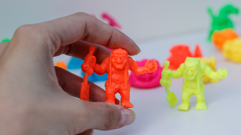 A person playing with neon cereal box toys