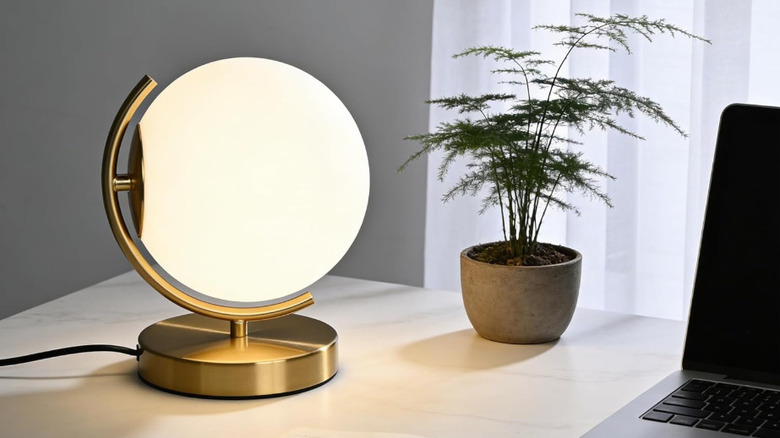 Antique House globe lamp on small table next to books