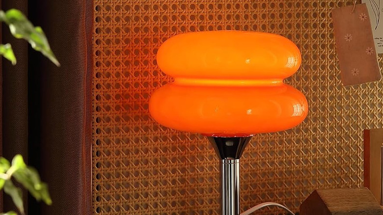 Glivpny mushroom lamp on table with black sofa in the background