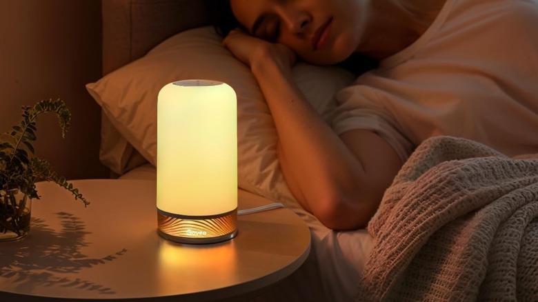 Govee lamp lit on lampstand next to bed
