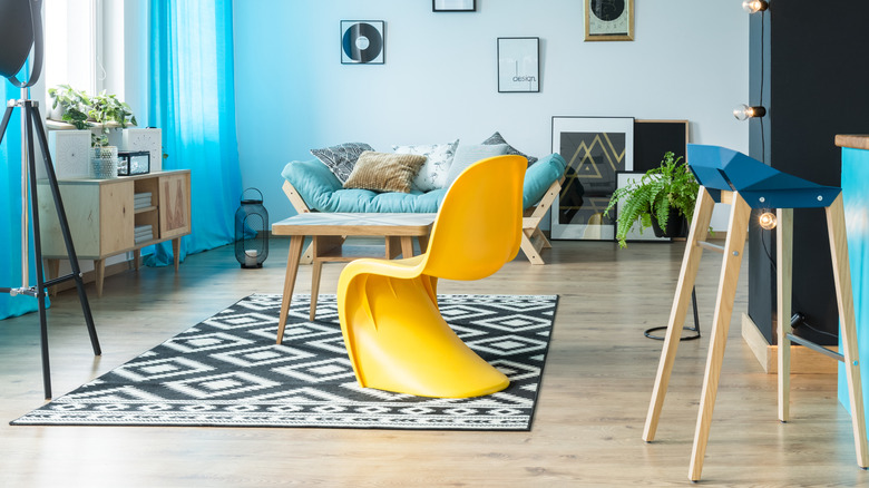 living room with teal futon and yellow funky bucket chair