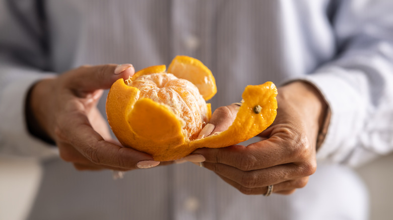 Person peeling an orange