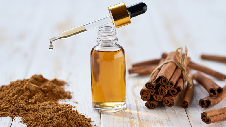 cinnamon oil, cinnamon sticks, and a pile of ground cinnamon