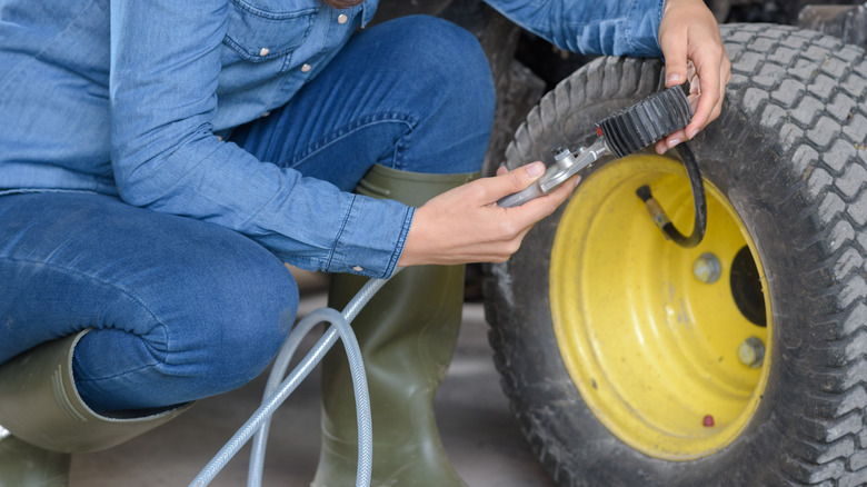 female worker measuring the pressure of the tires