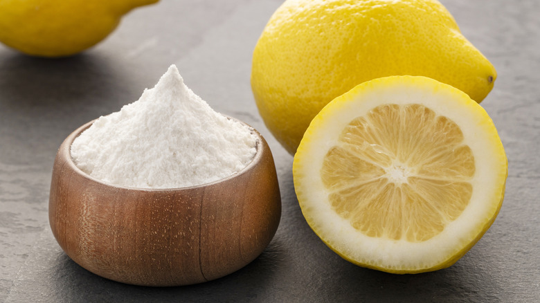 A bowl of baking soda with lemons next to it