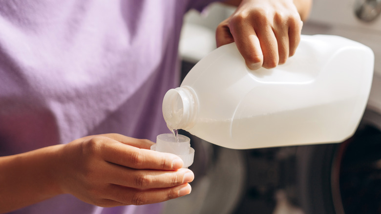 hands pouring liquid laundry soap