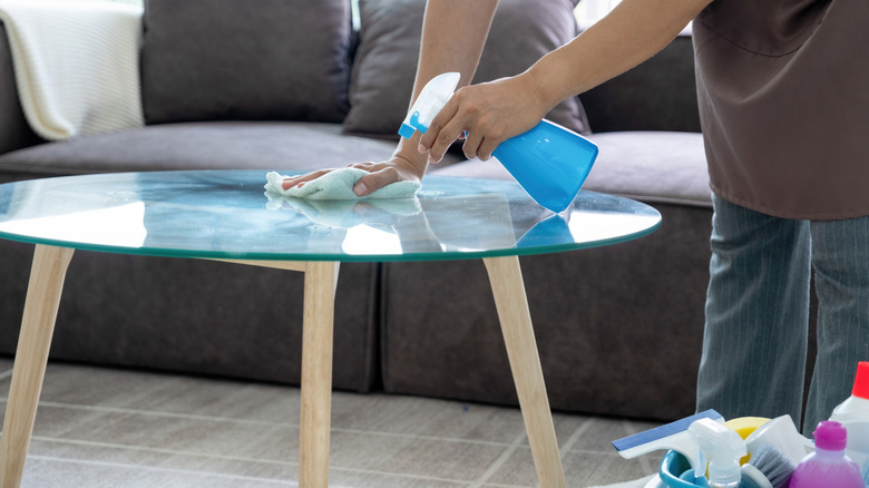 person cleaning coffee table