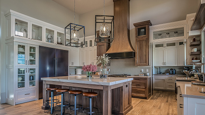 Large range hood with a wood finish extending to the ceiling in the kitchen