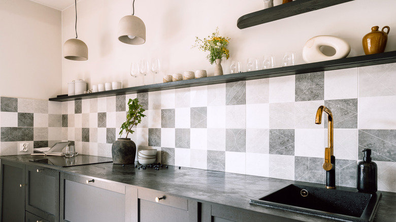 Black, gray, and white tiles creating a unique pattern on the backsplash in a kitchen