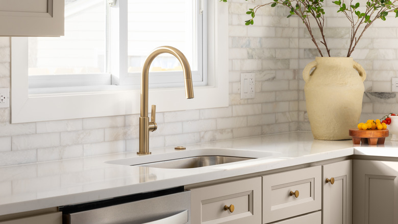 Sleek, modern, gold-tone kitchen faucet with a single handle on the side