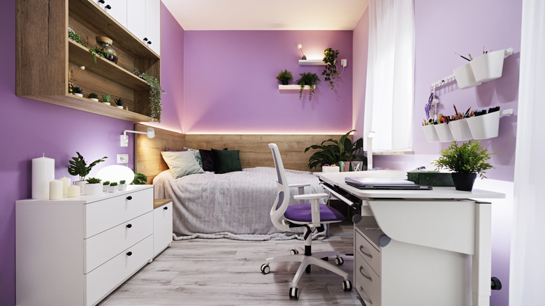 A lavender bedroom with white and brown furniture.