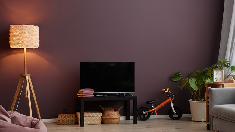 A mauve living room with kids toys out.
