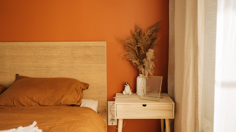 An orange wall in a bedroom