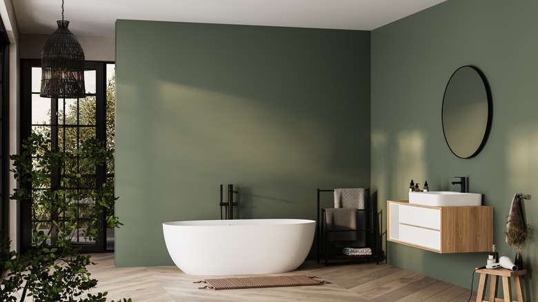 Trendy bathroom with muted green walls and wood flooring
