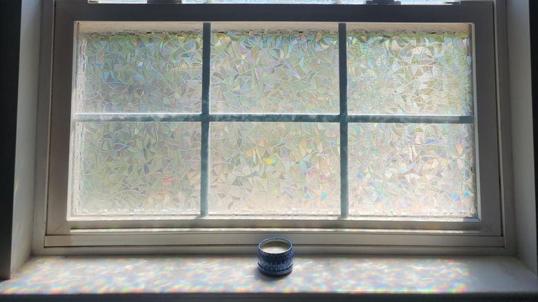 Rainbow window film on bathroom glass window with tiny candle