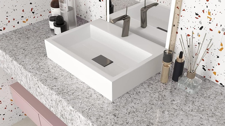 Granite contact paper wrapped around bathroom countertop with terrazzo walls