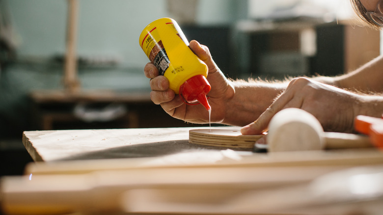 A person putting glue on a board