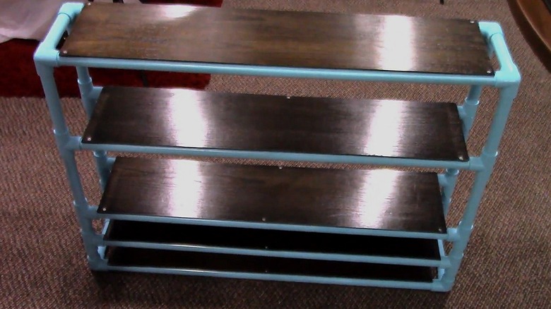 Shoe shelf made with a painted PVC pipe frame and plank shelves