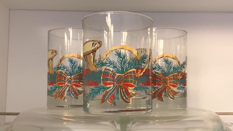 Three mid-century modern George Briard Christmas glasses with horns, pine boughs, and bows on them