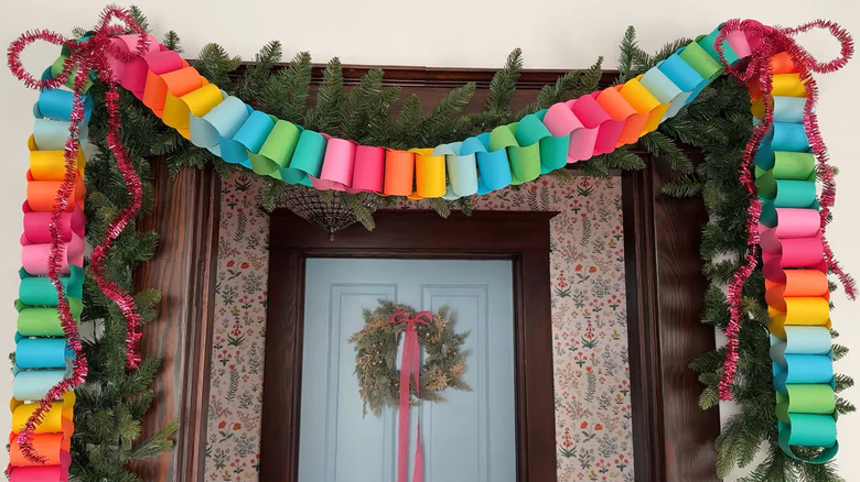 Colorful paper chains and pine garland draped around a door
