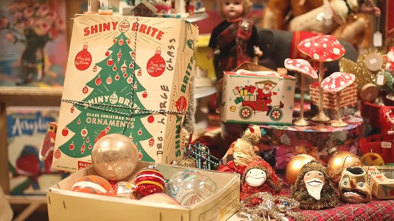 Vintage box of Shiny Brite ornaments next to other glass ornaments and Christmas decor
