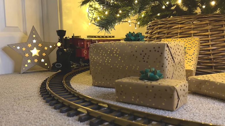 Toy train on a track running around the base of a Christmas tree
