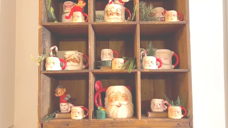 Cubby shelf filled with various Santa-face mugs