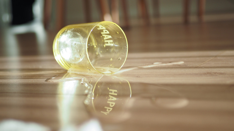 A cup of water spilled on wooden floor