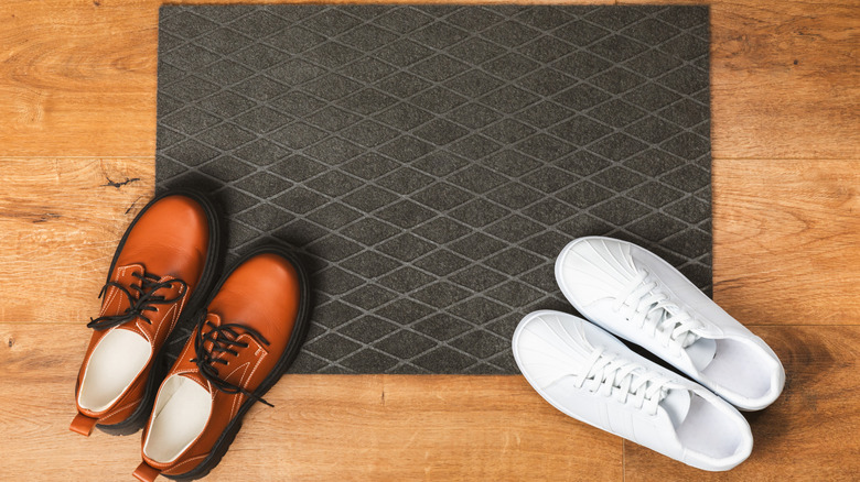An aerial view of a doormat with shoes