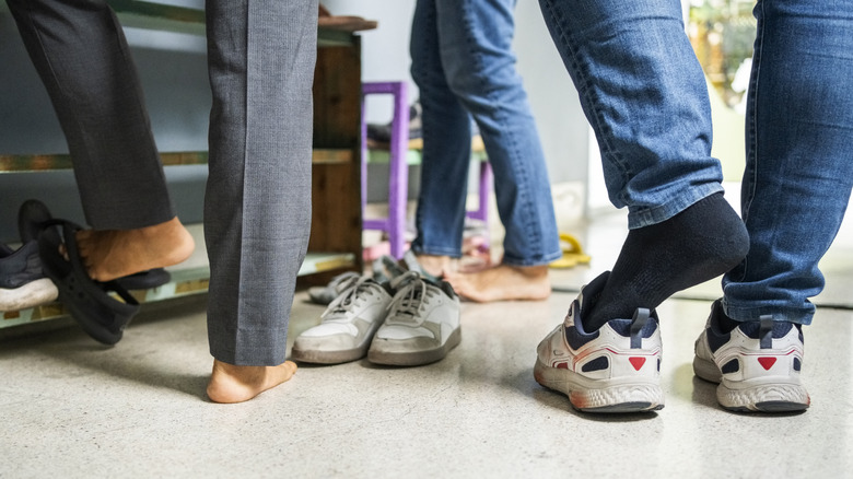 People removing their shoes at an entrance
