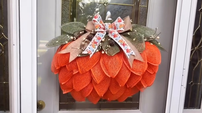 A pumpkin wreath on the front door of a house