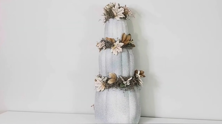 Silvery stacked pumpkins with fall decor in the middle
