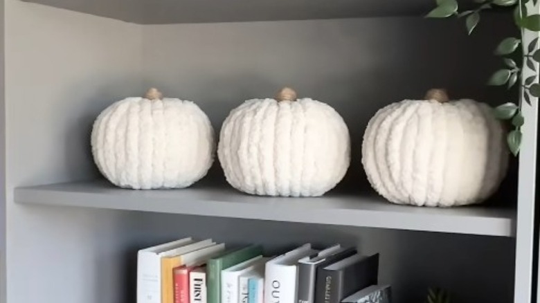 White fuzzy pumpkins on a bookshelf