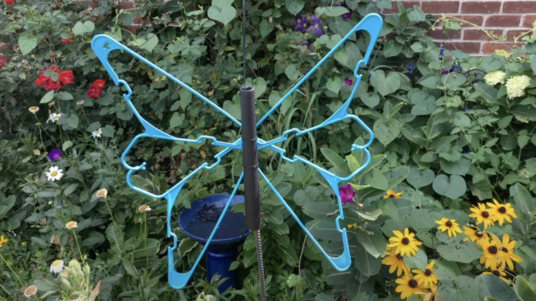 Butterfly garden art made from plastic hangers spray painted blue.
