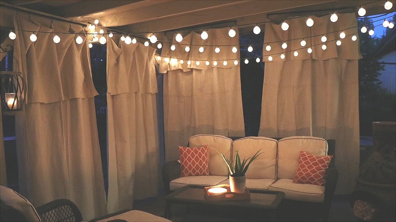 Drop cloth panels hung around a patio with string lights