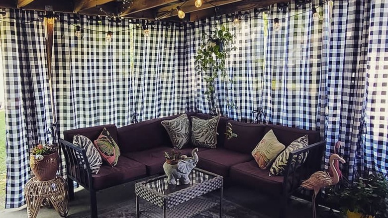 Black-and-white gingham patio curtains hanging behind a couch