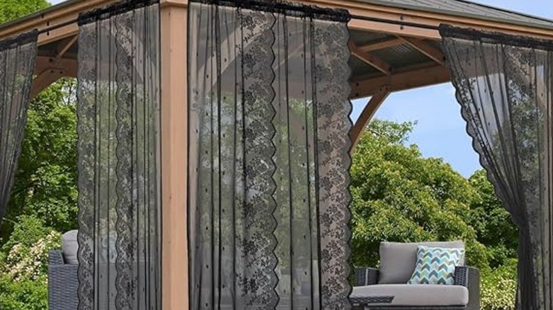 Black lace outdoor curtains hanging up in a ramada