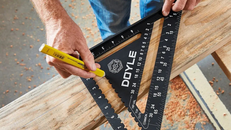 Woodworker measuring plank with rafter square