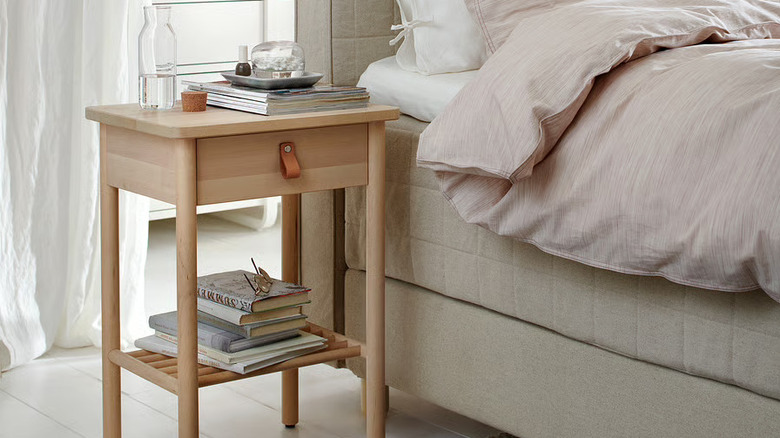 BJORKSNAS nightstand in bedroom next to bed with books on nightstand