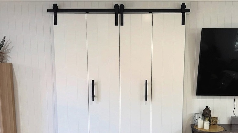 Close-up view of white bifold barn doors with black hardware