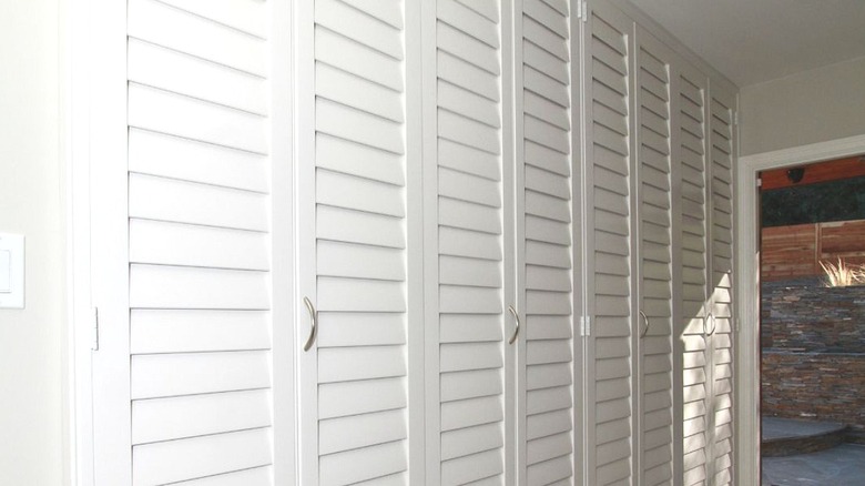 White louvered closet doors in an entry