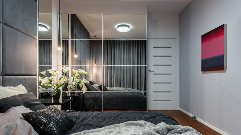 Glass paneled mirror-covered closet doors in bedroom
