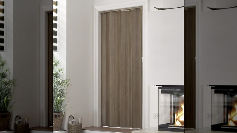 Brown accordion-style closet door in a white room