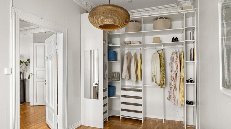 Open concept closet containing organized clothes and shoes