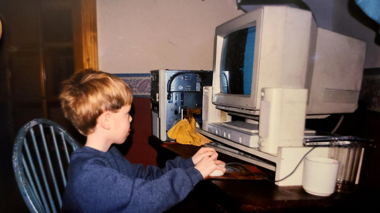 Little boy playing a big vintage computer