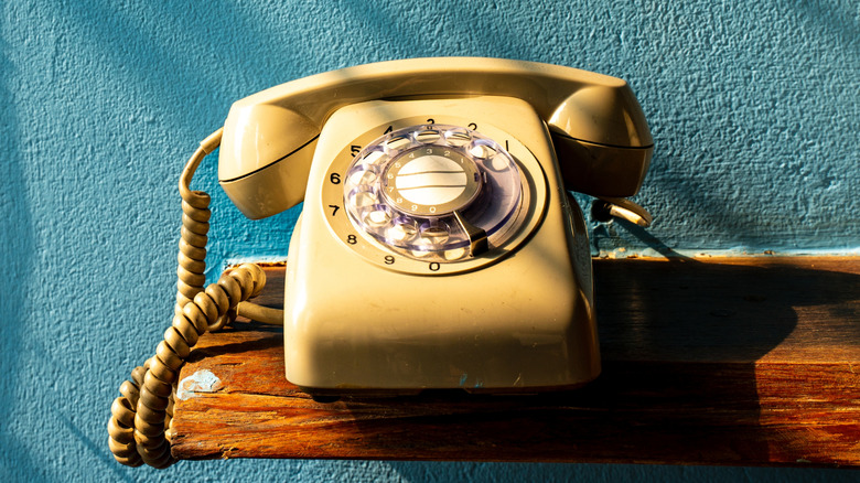 Vintage rotary phone on a wooden shelf