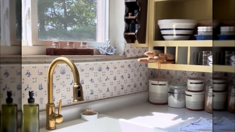 Butter yellow kitchen shelving with a blue and white backsplash